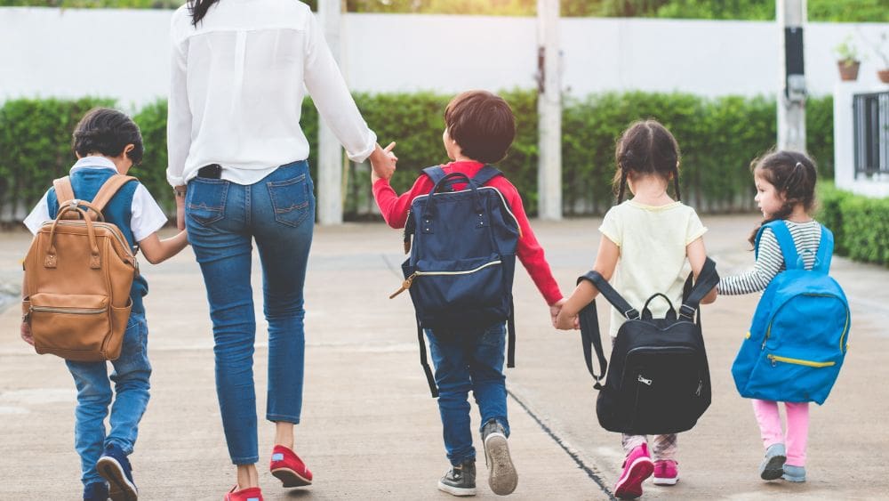 Children walking to school with backpacks.